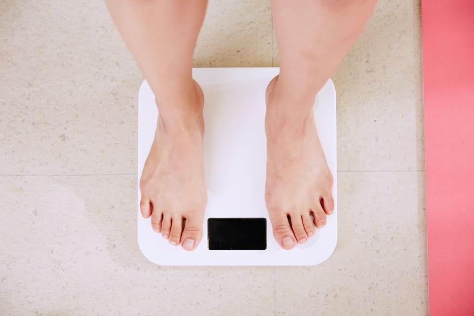 A person standing on a scale weighing themselves