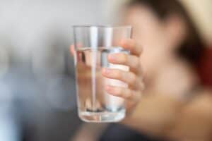 Someone holding a glass of water