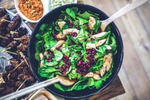 A bowl of salad surrounded with dips. Healthy eating is one way to help avoid weight gain.